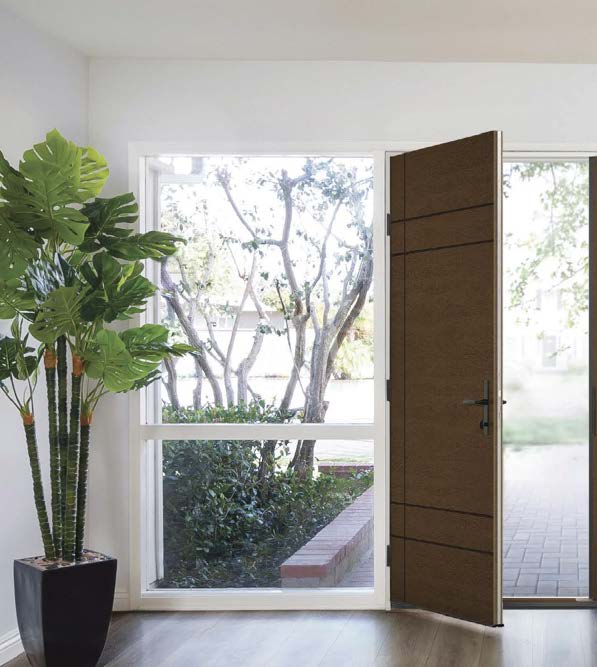 Brown timber door open to a sunlit garden
